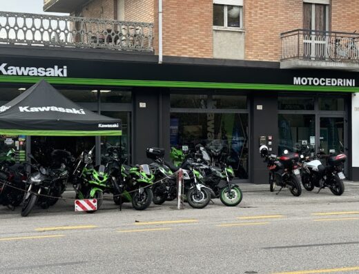 Moto Cedrini Kawasaki, Voge e CF Moto dealership in Ferrara, Italy, featuring parked motorcycles and a Kawasaki branded tent.