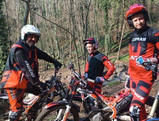 Tre piloti di motocross in posa con le loro moto da trial durante un evento del Moto Club Veneto Eventi SSDRL