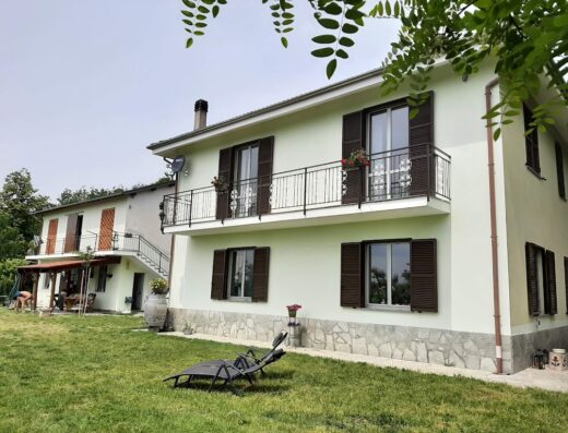 Moto Pareto B&B: Facciata esterna della struttura ricettiva con balconi fioriti, giardino curato e sdraio per il relax dei motociclisti in viaggio.