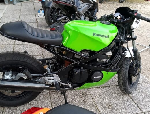 Moto Kawasaki verde customizzata, con sella monoposto nera e numero 40 sul manubrio, ideale per appassionati di moto e customizzazioni uniche.