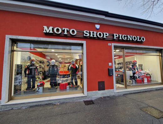 Facciata del negozio Moto Shop di Pignolo Gabriele C Sas con vetrine che espongono abbigliamento e accessori per motociclisti, caschi e moto