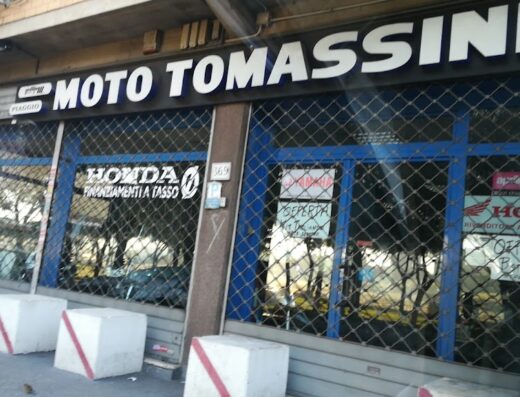 Moto Tomassini Srl Concessionario Sym - QJ Motor Roma: vetrina del negozio con insegne di concessionario moto Honda, Aprilia e Yamaha a Roma, offerte di finanziamento a tasso agevolato.