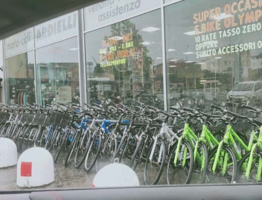 Motocicli Ardielli: esposizione di biciclette e e-bike di fronte al negozio, con offerte speciali e accessori omaggio. Servizi di vendita e assistenza.