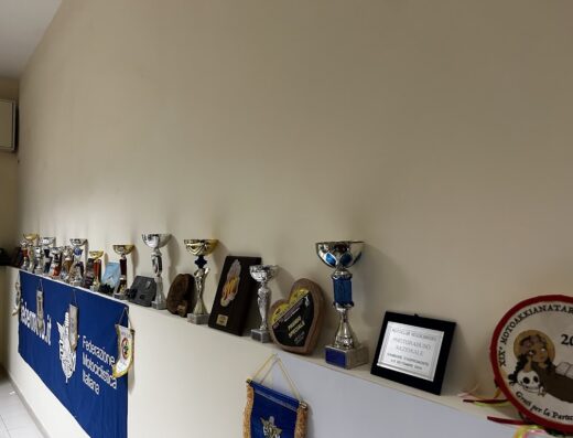 Collezione di trofei e riconoscimenti del Motoclub Reggio Bikers ASD, esposti su una mensola, testimonianza di successi nel motoraduno e nell'ambito motociclistico.