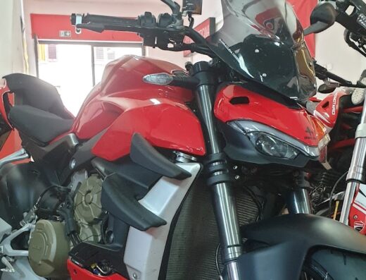 Motofficina Desmo Tech: Dettaglio di una Ducati Streetfighter rossa in officina, con un'altra moto Ducati sullo sfondo. Servizi di riparazione e manutenzione moto.