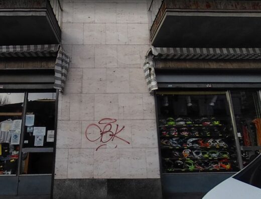 Vetrine di Motoforniture Gallaratese, negozio di ricambi e abbigliamento moto, con esposizione di caschi e accessori per motociclisti.