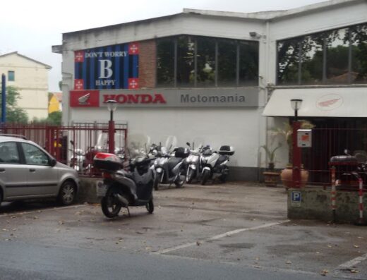 Motomania di P. Campani & C. Snc, concessionaria Honda moto, con esposizione di scooter e moto Honda parcheggiate all'esterno.