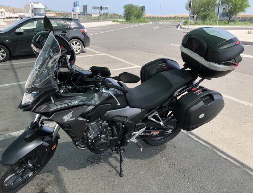 Motonoleggio: Honda CB500X grigia accessoriata con bauletto e valigie laterali, ideale per il noleggio moto e viaggi avventura.