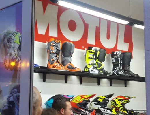 Vetrina del negozio Motor Life Factory di Federico Lisitano con stivali da motocross Motul e caschi colorati esposti, accessori per motociclisti e amanti del viaggio in moto.