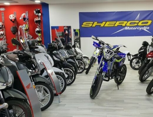 Negozio di moto con esposizione di scooter Honda, moto Sherco e caschi da moto. Vasta scelta di modelli e accessori per motociclisti e appassionati di viaggi su due ruote.