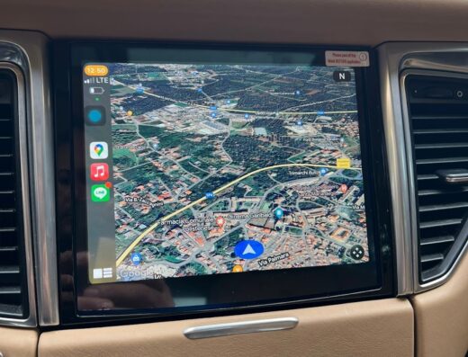 Interni di una Porsche con il sistema di navigazione satellitare in funzione, che mostra una mappa dettagliata della zona di Polistena, Calabria.