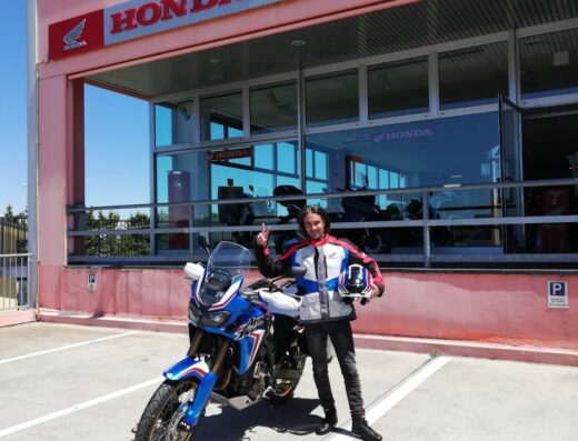 Un motociclista posa con la sua Honda Africa Twin di fronte a Motor Sport di Ruzzante s.a.s, concessionaria moto e accessori.