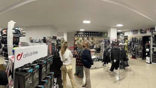 Interno del negozio Motor Store srl con caschi moto, abbigliamento tecnico, accessori e clienti. Vasta selezione per motociclisti.