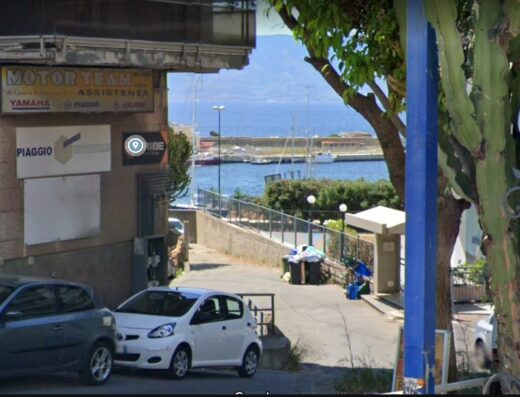 Motor-team Snc: Officina moto e centro assistenza Yamaha, Piaggio, Gilera. Vista esterna con auto parcheggiate e scorcio sul mare.