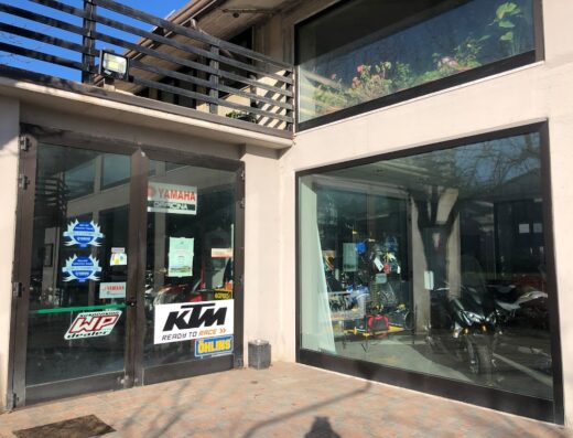 Entrata di Motor Trend Potenza, concessionaria moto Yamaha e KTM con adesivi WP dealer e Ohlins, vetrina con accessori e moto visibili