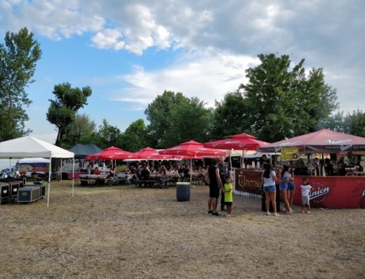 Evento del Motorclub Nord Est Bikers con stand gastronomici, tavoli all'aperto e atmosfera conviviale per appassionati di moto e viaggi.