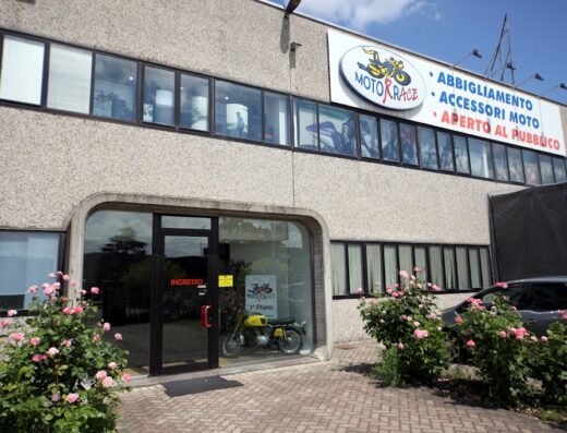 MotorRace Segrate: negozio di abbigliamento moto, caschi e accessori. In vetrina una moto gialla d'epoca. Vasto assortimento per motociclisti e appassionati di viaggi in moto.