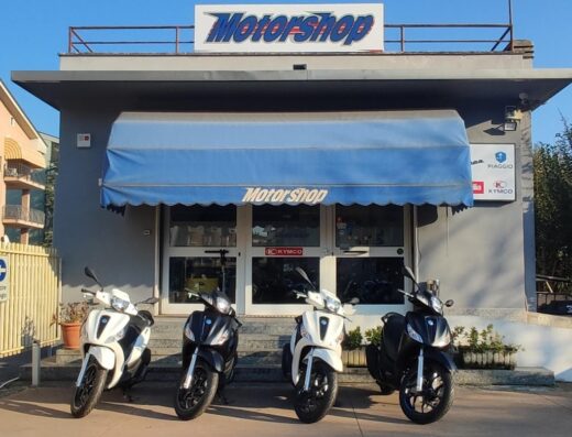 Motorshop Verona concessionario Piaggio Vespa Kymco: esposizione di scooter Piaggio e Kymco davanti al negozio.
