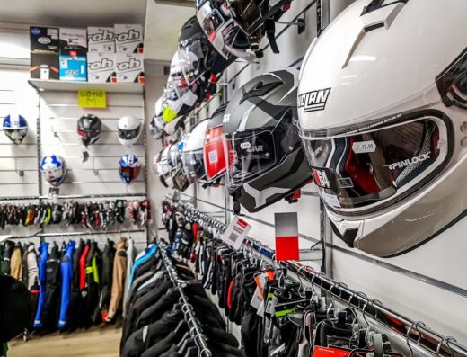 Negozio di accessori moto con caschi Nolan e Givi in esposizione, abbigliamento tecnico e guanti, per motociclisti e appassionati di Motorstock.