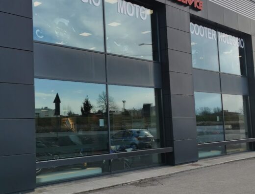 Foto della facciata di un negozio Yamaha Motoservice con vetrine che mostrano servizi di noleggio moto e scooter.