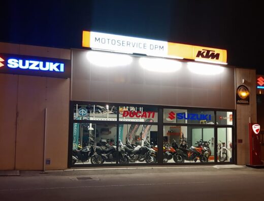 Motoservice D.P.M. di Massimo Del Pioluogo: esterno dell'officina con vetrine espositive di moto Ducati, Suzuki e KTM. Servizi di riparazione e vendita accessori moto.