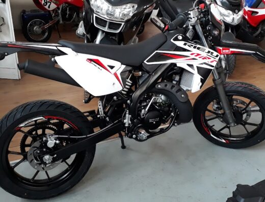 Rieju MRT motorcycle in a showroom, a black and white supermoto bike, displayed at Motosimo, a motorcycle marketplace