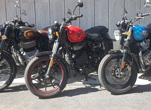 File di moto Royal Enfield di diversi colori parcheggiate per il servizio di noleggio moto e accessori