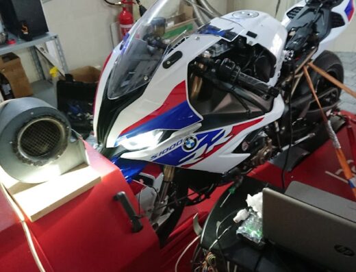BMW S1000 RR bianca, rossa e blu su banco prova potenza. Accessori moto e diagnosi motore in officina specializzata Mototronik.