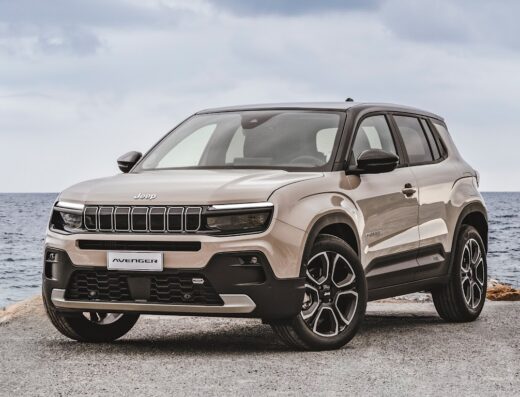 Jeep Avenger SUV in a beige color parked near the ocean, showcasing its modern design and rugged appeal for adventurous travels.