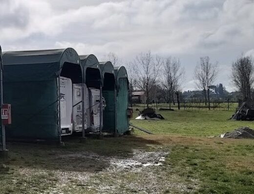 Rimessaggio camper Multiservice Lucci: vista esterna delle strutture di stoccaggio coperte per camper e caravan, con area verde circostante.