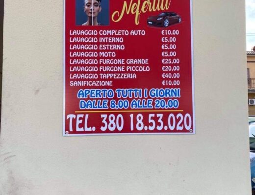 Insegna di autolavaggio a mano "Nefertiti" con listino prezzi: lavaggio auto, interno, esterno, moto, furgone grande/piccolo, tappezzeria e sanificazione.