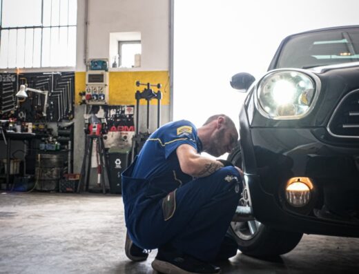 Meccanico specializzato Elettrocar controlla lo pneumatico di un'auto elettrica in officina, manutenzione e riparazione di veicoli elettrici