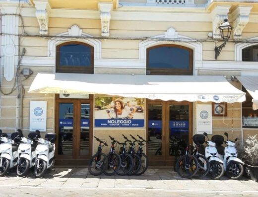 Negozio Nicolsport con scooter e biciclette elettriche a noleggio. Auto, scooter, e-bike e quad disponibili per esplorare la zona.
