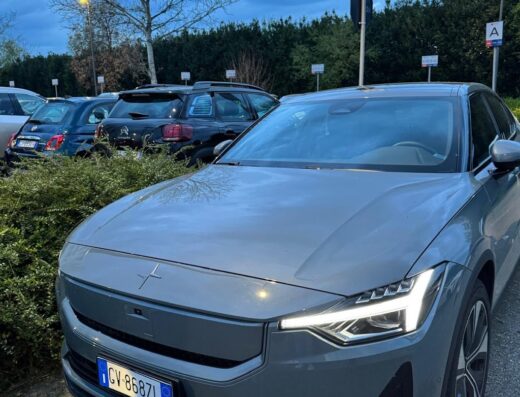 Gray Polestar 2 parked in a parking lot, showcasing a modern electric vehicle available for rent. The license plate is visible.