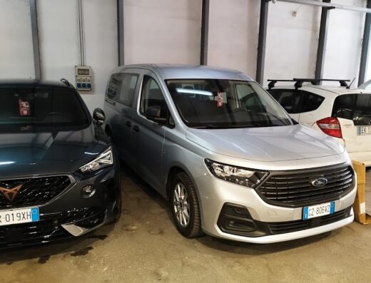 Noleggiare: Furgone Ford Transit Courier argento parcheggiato in un garage, ideale per il trasporto e il servizio di noleggio.