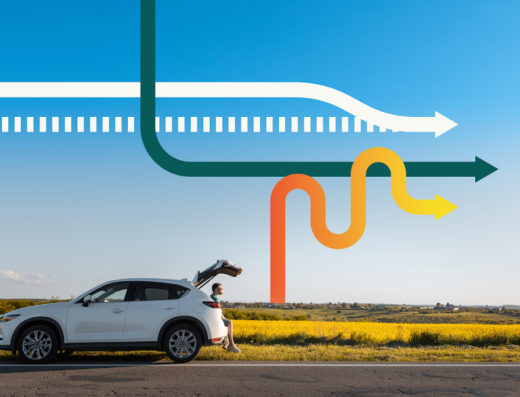 Un'auto bianca parcheggiata lungo una strada di campagna a Dueville, con una persona seduta nel bagagliaio aperto, sullo sfondo un campo giallo e frecce colorate che indicano percorsi di viaggio.