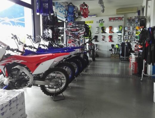 Interno di negozio "Non Solo Moto" con esposizione di moto Honda e Yamaha, abbigliamento tecnico, caschi e accessori per motociclisti.