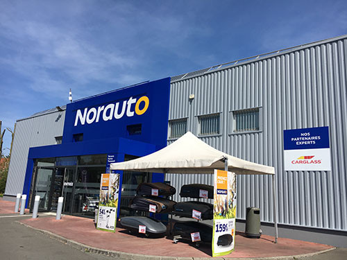 Norauto Brescia: Esterno del negozio Norauto che offre accessori auto e servizi di manutenzione. In primo piano, esposizione di box da tetto.