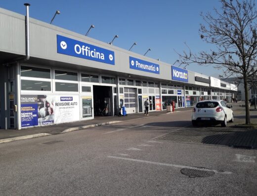 Norauto Ravenna: vista esterna del negozio con insegne "Officina", "Pneumatici", "Norauto", e servizi di tagliando e revisione auto.