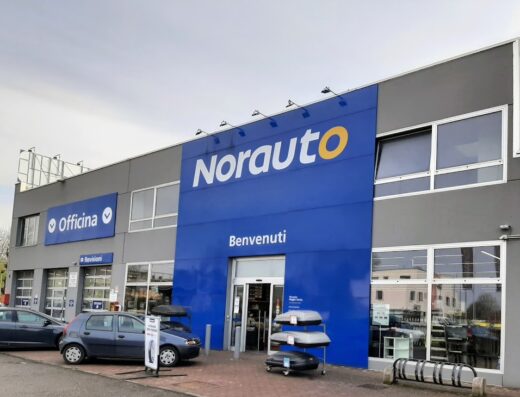 Norauto Reggio Emilia negozio: vista esterna dell'edificio con insegna ben visibile, accessori auto esposti e ingresso con scritta "Benvenuti".