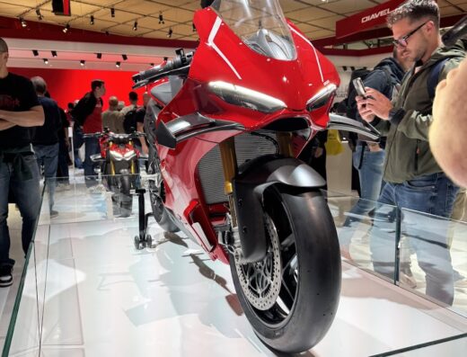 Nuova Moto Riviera Srls: Ducati rossa esposta in fiera, dettaglio del design e delle componenti meccaniche. Accessori moto visibili.