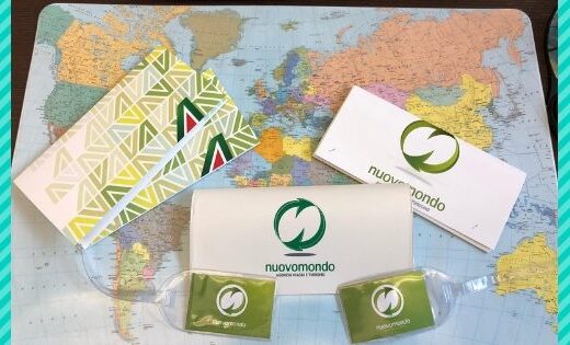 Materiale informativo e gadget dell'agenzia viaggi e turismo Nuovo Mondo di Aosta, su una mappa del mondo.