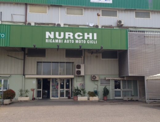 Foto della facciata di Nurchi Fausto & Figli S.R.L., negozio di ricambi auto, moto e cicli in Italia, con insegna verde ben visibile.