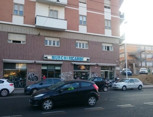 Nurchi Ricambi Moto, negozio di accessori e ricambi per moto a Roma, con auto parcheggiate di fronte. Vendita e assistenza per motociclisti.