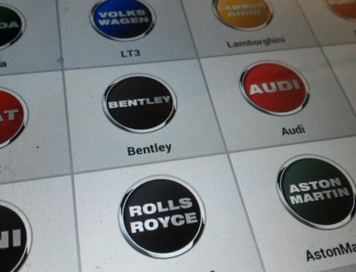Screenshot of a diagnostic tool interface in an Officina Aeffe Tech, showing car brand logos like Skoda, Volkswagen, Lamborghini, Bugatti, Seat, Bentley, Audi, Rolls Royce, Aston Martin, Mini used for motorcycle diagnostics and repair services.