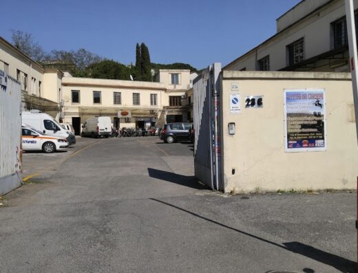 Ingresso dell'Officina del Centauro, specializzata in riparazioni moto e diagnosi elettronica. Parcheggio con moto visibili. Accesso con sbarra automatica.