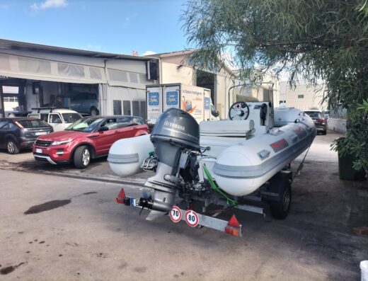 Gommone Yamaha su rimorchio presso l'Officina e Centro Revisioni Mariano Pietro, con auto parcheggiate sullo sfondo