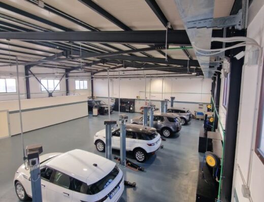 Interno dell'officina G.F. Motori a Reggio Calabria, con auto Land Rover in manutenzione su ponti sollevatori. Servizi autorizzati per la provincia.