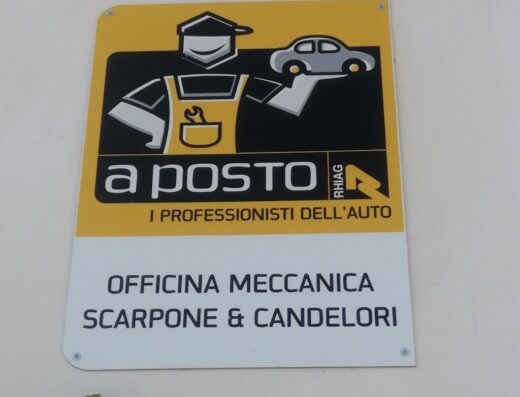 Insegna di Officina Meccanica Scarpone Vincenzo & Candelori A.: logo con meccanico stilizzato e auto, "a posto", "i professionisti dell'auto".