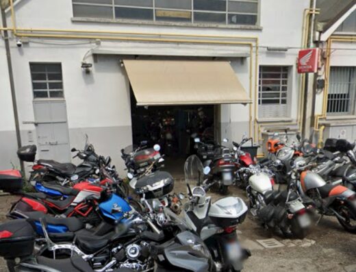 Officina Moto Bianconcini: esterno dell'officina con diverse moto parcheggiate, inclusi scooter e moto da turismo, in attesa di riparazione o manutenzione.
